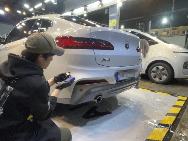 본격적인 코팅 단계로 넘어가면서 전면 BMW 엠블럼 앞에 유리막 제품과 보증서가 나란히 놓였습니다.